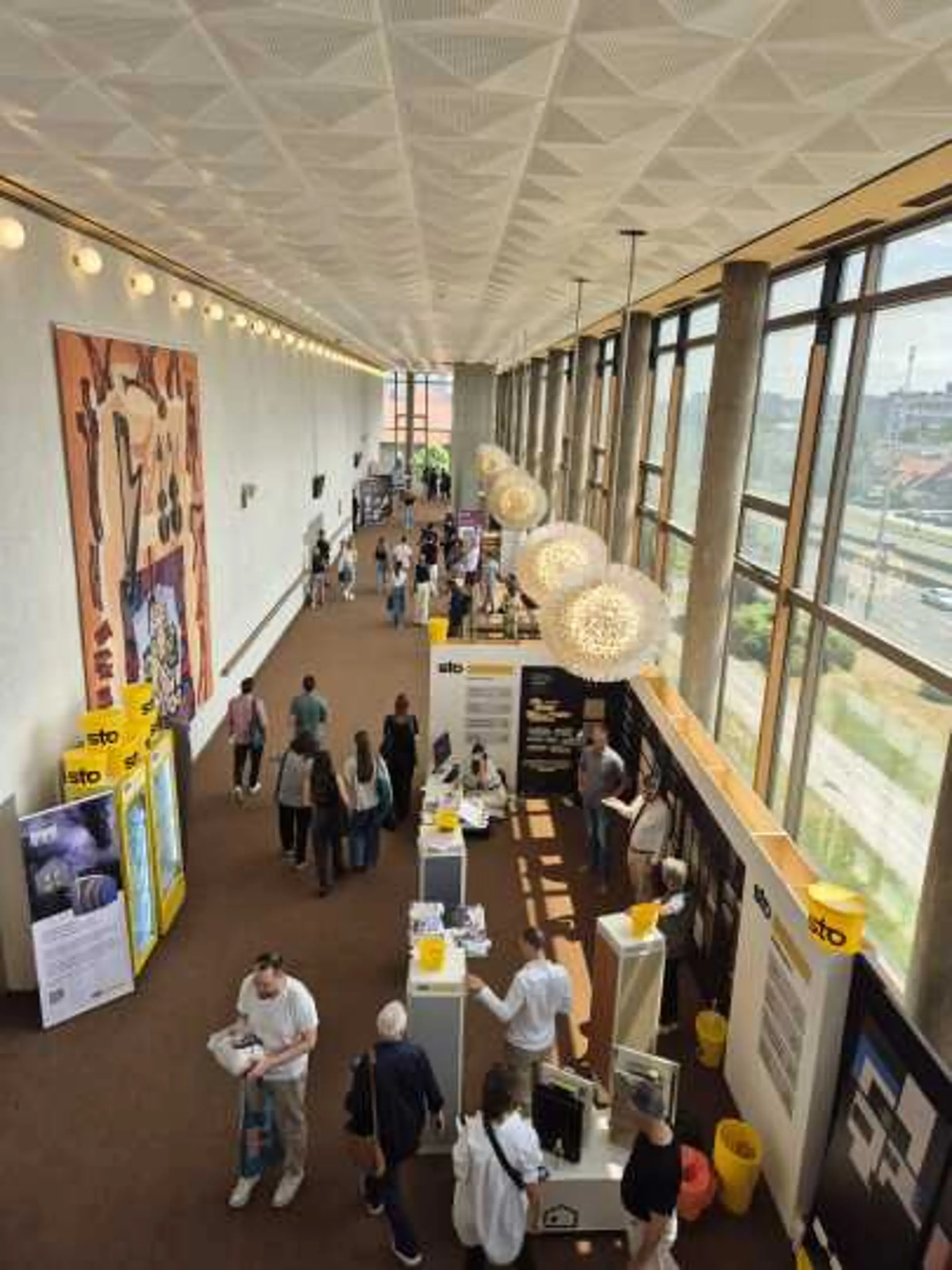 Pogled odozgo na Sto izložbeni kutak u hodniku Days of Oris, posjetitelji razgledavaju uzorke.